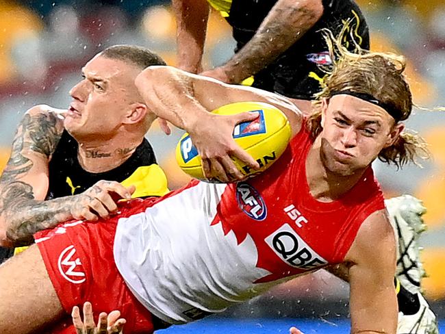 BRISBANE, AUSTRALIA - JULY 12: James Rowbottom of the Swans is pressured by the defence of Dustin Martin of the Tigers during the round 6 AFL match between the Richmond Tigers and the Sydney Swans at The Gabba on July 12, 2020 in Brisbane, Australia. (Photo by Bradley Kanaris/Getty Images)