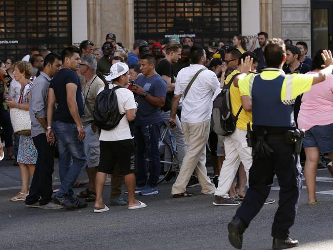 Policemen ask people to move back near a cordoned off area after a van ploughed into the crowd. Picture: AFP