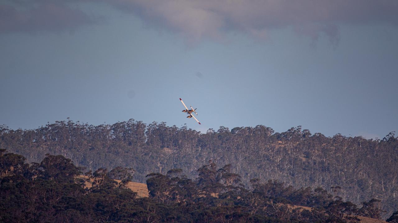 A planes circles over North West Bay to pick up water. Picture: Linda Higginson