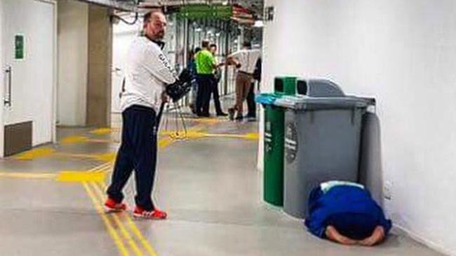 British judoka Ashley McKenzie has his head in his hands behind a garbage bin.