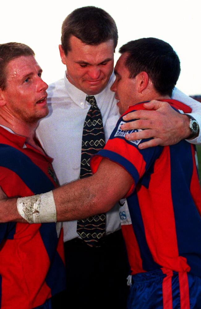 Paul Harragon embraces Bill Peden and Matthew Johns in 1999.