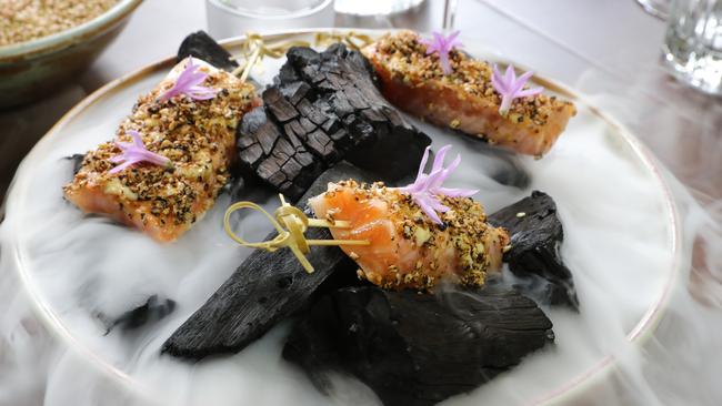 The presentation is impressive at Ms Moneypenny’s — chargrilled ora king salmon stick, served atop dry ice. Picture Glenn Hampson