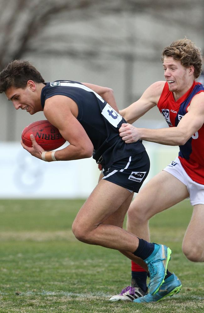 Alex Federico tries to break free of a tackle from Coburg’s Josh Guthrie. Picture: Hamish Blair.