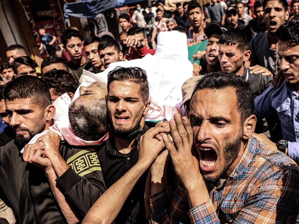 Mourners carry the body of Majd Abu Saadahthe, a Palestinian killed in an Israeli air strike, during his funeral in the town of Khan Yunis in the southern Gaza Strip. Picture: Said Khatib/AFP)