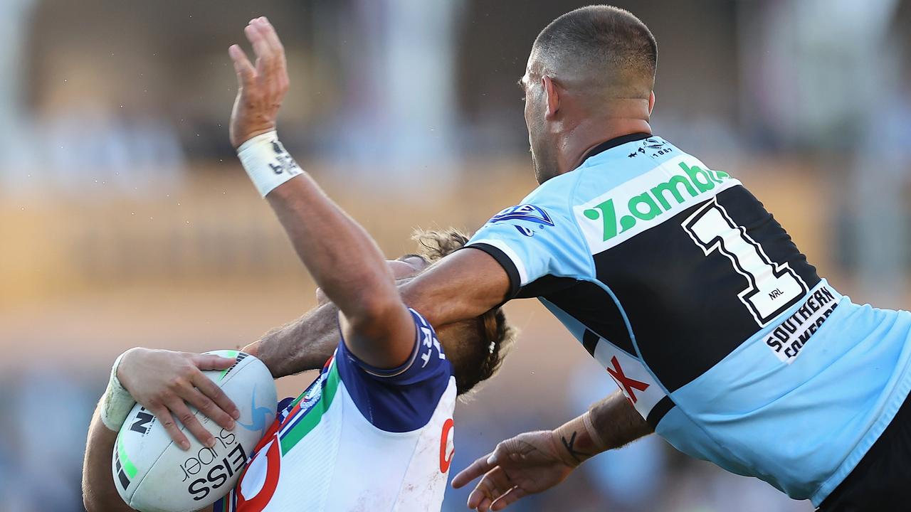 William Kennedy of the Sharks tackles Reece Walsh. Photo by Cameron Spencer/Getty Images