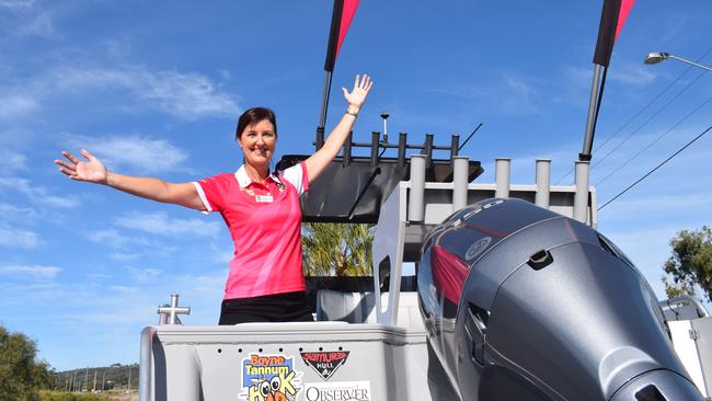 Boyne Tannum HookUp committee president Jennifer McGuire with the major prize a Sea Jay 630 Vision centre console boat powered by a 150hp Yamaha outboard and Raymarine electronics.