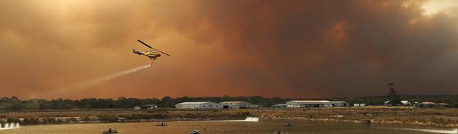 A water-bombing firefighting helicopters loaded with water at a local prawn farm at Baffle Creek, near Deepwater. Picture: Lyndon Mechielsen/The Australian