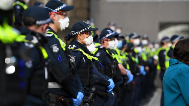 Masked Victoria Police officers stand guard ahead of the protest. Picture: AAP Image/James Ross