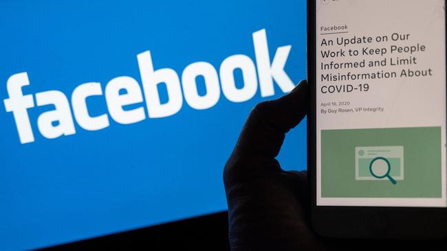 A smart phone screen displays a new policy on Covid-19 misinformation with a Facebook website in the background in Arlington, Virginia. Picture: AFP