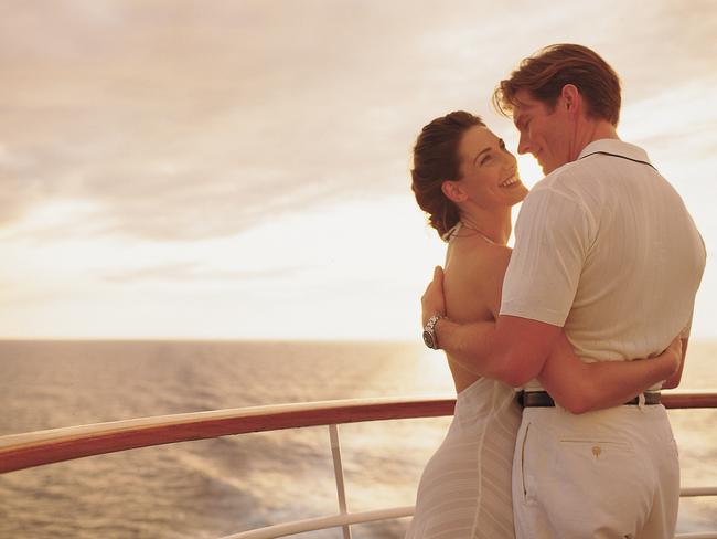 Generic pic of a couple embracing while standing on the deck of a Pride of Aloha cruise ship out at sea.