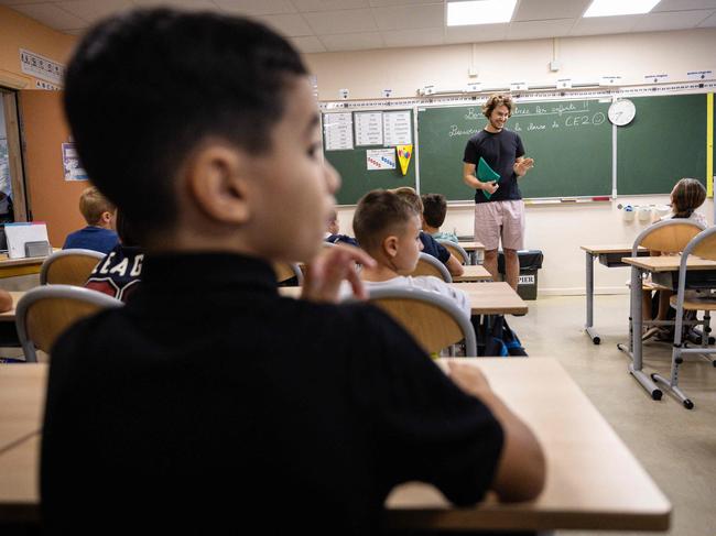 School children are welcomed by their teacher while enterring their classroom on the first day of the new school year at Bonnevaine Zenatti primary school in Marseille, southeastern France, on September 2, 2024. (Photo by CLEMENT MAHOUDEAU / AFP)