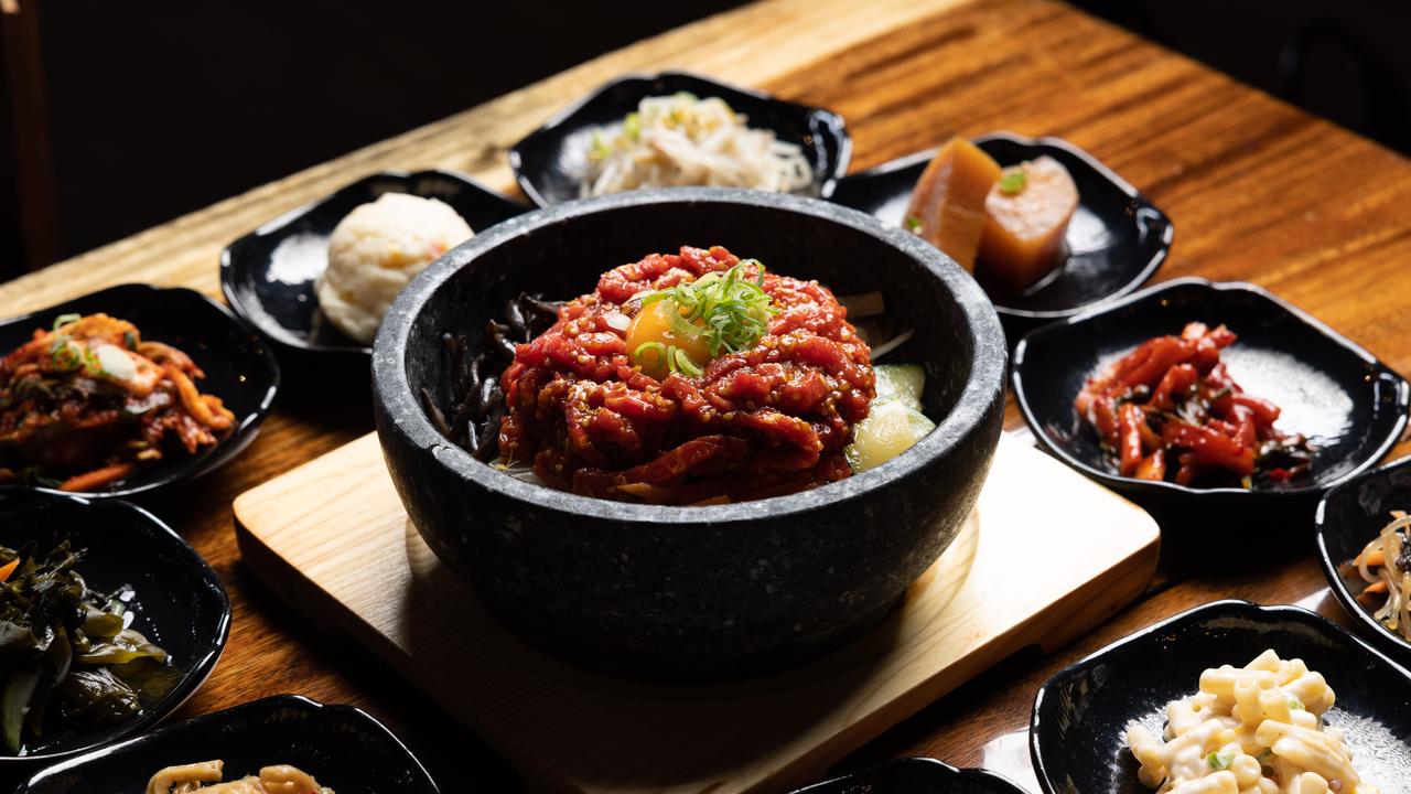 Bibimbap in hot stone bowl (in the centre) surrounded by banchan. Picture: David Kelly