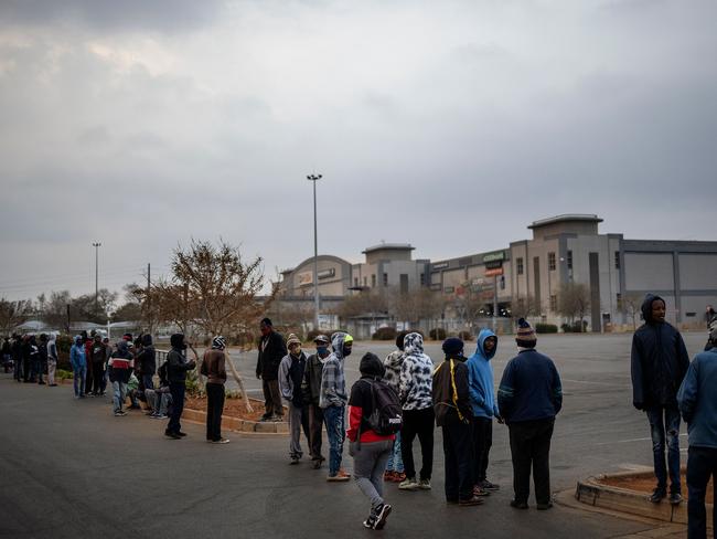 Customers queue while waiting for the opening of a liquor shop in Lenasia, Johannesburg. Picture: AFP