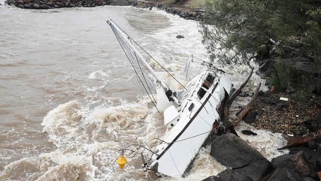 A yacht, swept away by the waves, rests at Point Danger on the southern end of the Gold Coast on Friday. Picture: AFP