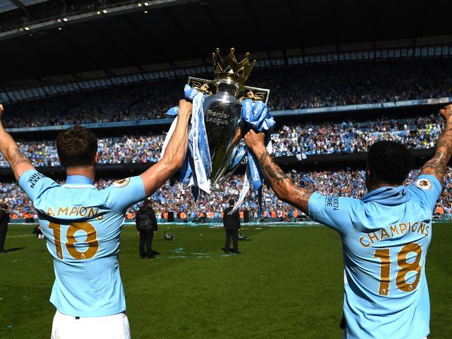 MANCHESTER, ENGLAND - MAY 06:  John Stones of Manchester City holds the Premier League Trophy with Kyle Walker of Manchester City towards the fans during the Premier League match between Manchester City and Huddersfield Town at Etihad Stadium on May 6, 2018 in Manchester, England.  (Photo by Michael Regan/Getty Images)