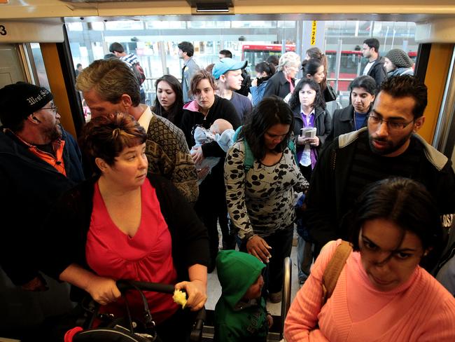 No social distancing here … Commuters enter a packed train on the western line in Sydney.