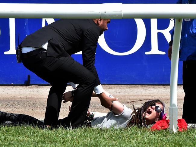 Protesters handcuff themselves to the inside rail before the start of the race.