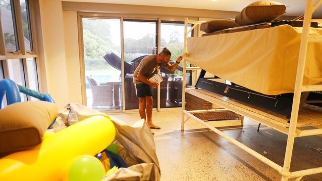 Sam Longo at his home in East Hills preparing for the 4.3m peak of the Georges River. Picture: John Grainger