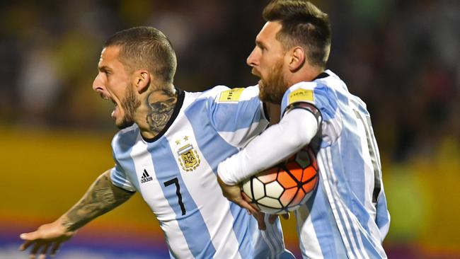 Argentina's Lionel Messi (R) celebrates with teammate Dario Benedetto after scoring against Ecuador.