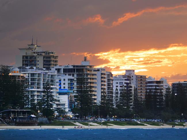 The sun sets behind the high rises at Mooloolaba Beach. Photo Lachie Millard