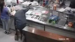 The man then takes the pizza box off the counter.