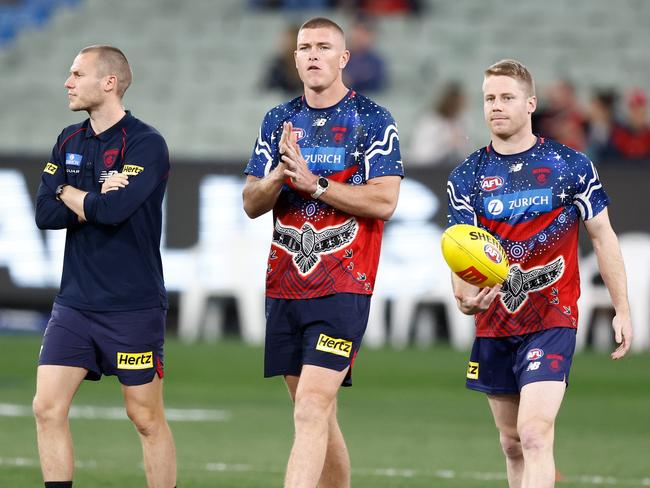 MELBOURNE, AUSTRALIA - SEPTEMBER 15: (L-R) Ed Langdon, Adam Tomlinson and Lachie Hunter of the Demons warm up during the 2023 AFL First Semi Final match between the Melbourne Demons and the Carlton Blues at Melbourne Cricket Ground on September 15, 2023 in Melbourne, Australia. (Photo by Michael Willson/AFL Photos via Getty Images)