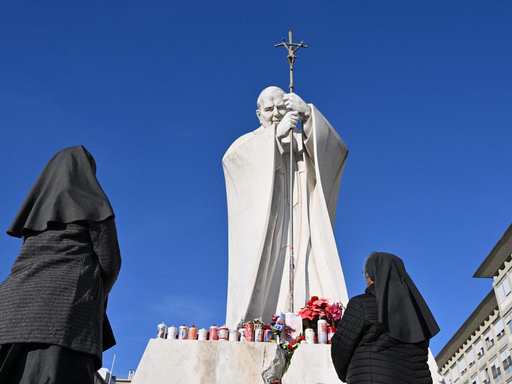 Nuns pray at the statue of John Paul II outside the Gemelli hospital. Picture: AFP