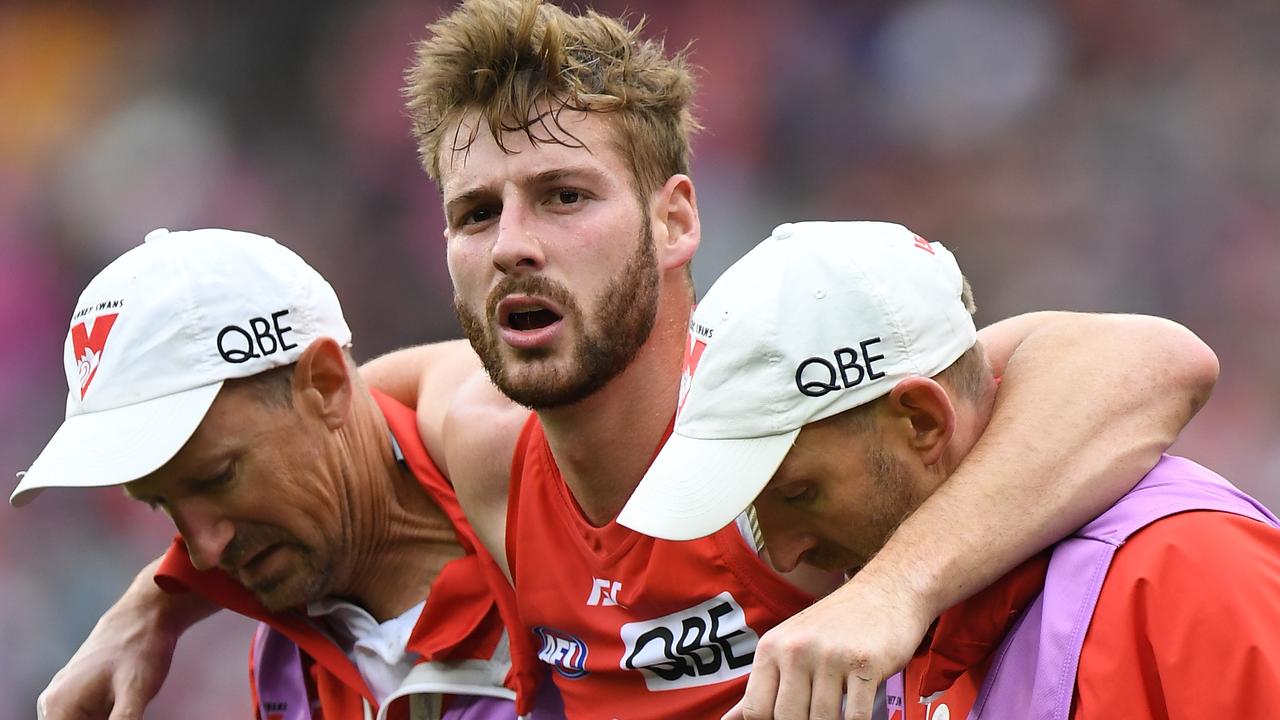 Alex Johnson of the Swans (centre) is seen after sustaining an injury during the Round 21 AFL match between the Melbourne Demons and the Sydney Swans at the MCG in Melbourne, Sunday, August 12, 2018. (AAP Image/Julian Smith) NO ARCHIVING, EDITORIAL USE ONLY