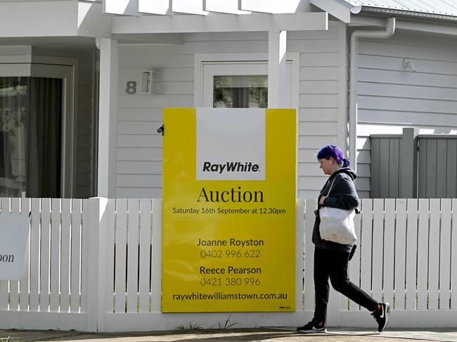 A woman walks past an auction sign outside a house in Melbourne on September 5, 2023 as the Reserve Bank of Australia (RBA) prepares to make it's monthly monetary policy decision on interest rates. (Photo by William WEST / AFP)