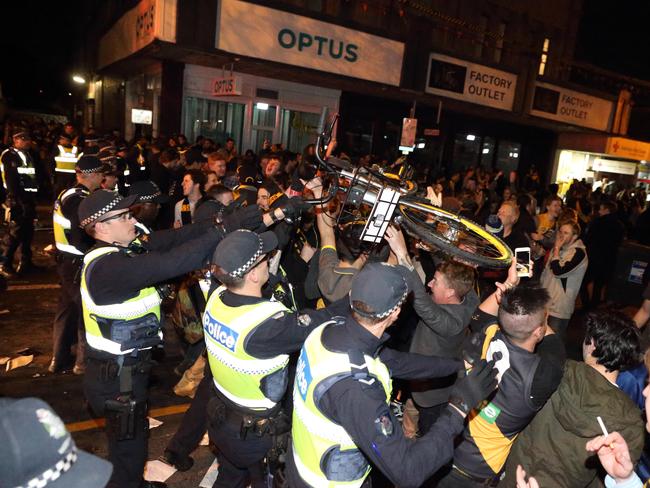 A bike is thrown over a police line in Swan St. Picture: Patrick Herve