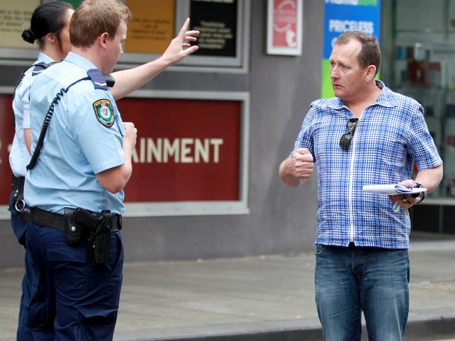 Jamie Fawcett speaking with police in Kings Cross after an alleged altercation with another photographer nearby.