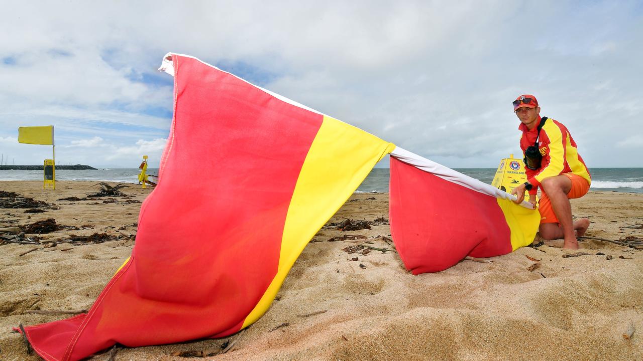 Lifeguard Tarryn Hayden pulls the flag down at Harbour Beach in Mackay. Picture: Tony Martin