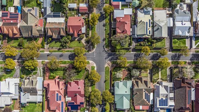 Aerial view of leafy eastern suburban houses on 4-way cross road intersection in Adelaide, South Australia: directly above, rooftop solar, trees. Housing property generic