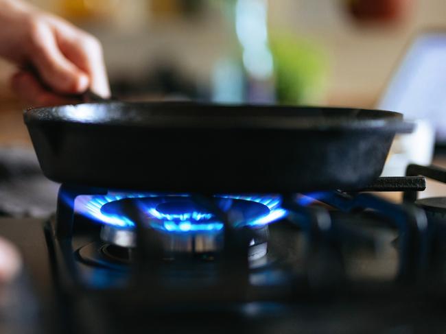 An anonymous man preparing lunch in a pan in the kitchen.