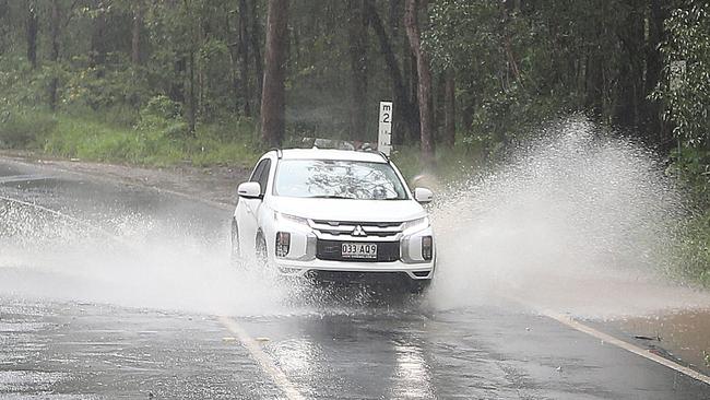 Water flows over Old Coach Rd at Tallebudgera on Saturday. Picture: Mike Batterham