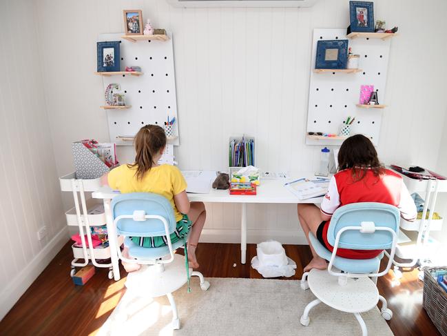 Audrey Merriman (right), 9, and her sister Grace, 8, are seen learning from home on the first day of Term 2 in Brisbane, Monday, April 20, 2020. Only the children of essential workers and students deemed vulnerable are expected at Queensland schools as part of the efforts to fight the COVID-19 pandemic. (AAP Image/Dan Peled) NO ARCHIVING