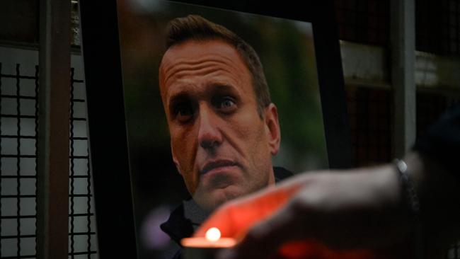 A person lights a candle by a portrait of late Russian opposition leader Alexei Navalny at the entrance of the Chancery of the Embassy of the Russian Federation in Pristina. Picture: AFP