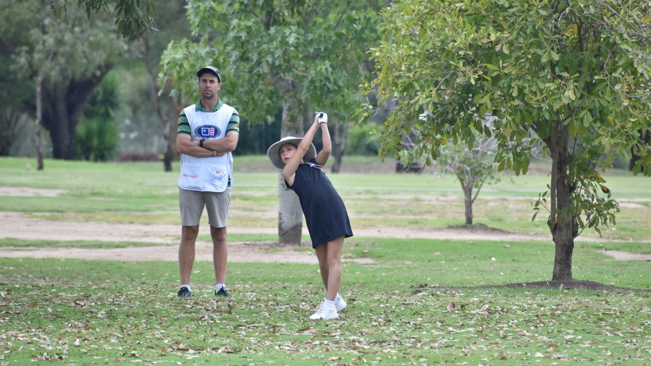 Caddie Barrie Manning watches on as Emilia Patrizi (girls nine to 10 years) shoots for the green at the US Kids Golf Foundation Australian Open at the Rockhampton Golf Club on September 28.