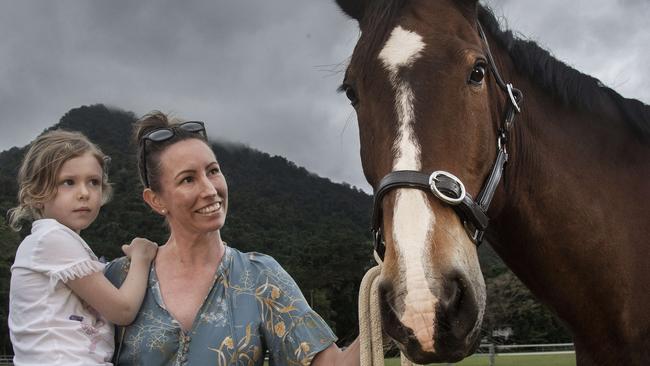 As rain clouds gather over Mt Whitfield way mum Tara Moses and daughter Aylah put their horse Nash away for the night at the Redlynch Equestrian Association grounds. Picture: Brian Cassey