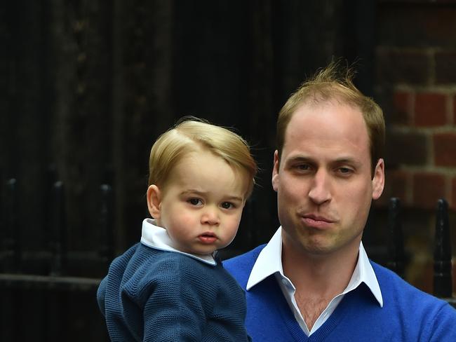 Britain's Prince William, Duke of Cambridge (R), carries his son Prince George of Cambridge as they return to the Lindo Wing at St Mary's Hospital in central London, on May 2, 2015 where his wife Catherine, Duchess of Cambridge, gave birth to their second child, a baby girl, earlier in the day. The Duchess of Cambridge was safely delivered of a daughter weighing 8lbs 3oz, Kensington Palace announced. The newly-born Princess of Cambridge is fourth in line to the British throne. AFP PHOTO / BEN STANSALL