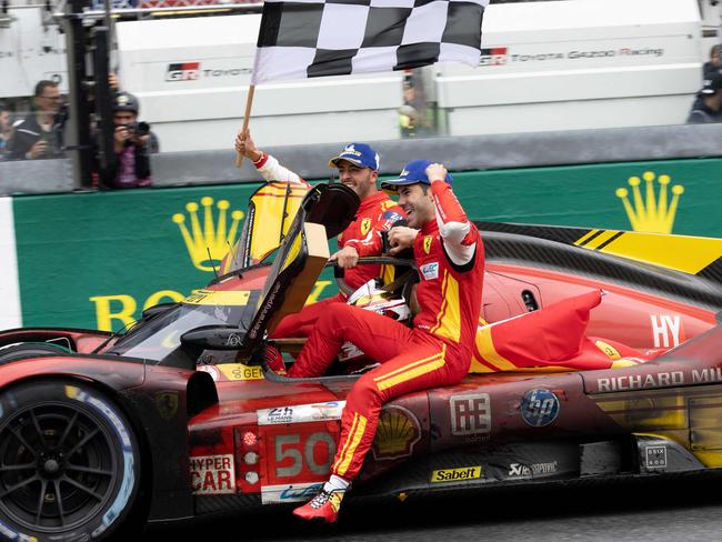 Ferrari 499P Hybrid Hypercar WEC's team, Spanish driver Miguel Molina (R) Italian driver Antonio Fuoco (L) and Danish driver Nicklas Nielsen (driving the car) celebrate after winning Le Mans 24-hours endurance race in Le Mans, western France, on June 16, 2024. Ferrari won a wild and wet 92nd edition of the Le Mans 24 Hours race on June 16, 2024, as Nicklas Nielsen took the chequered flag after a vintage and gruelling race, the Dane sharing driving duties in the Italian constructor's No 50 car with Italian Antonio Fuoco and Spaniard Miguel Molina. (Photo by FRED TANNEAU / AFP)