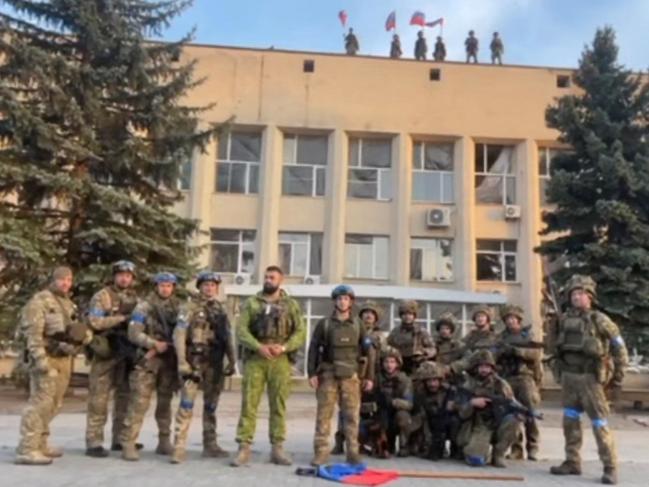 Ukrainian armed forces pose in front of Lyman Town Administration office, in Lyman, Ukraine, in this still image taken from a social media video. Picture: Supplied/81 Airborne Brigade of the Ukrainian Armed Forces/via Reuters