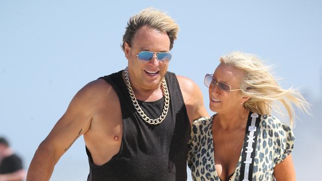Warwick Capper and fiance Lisa Arocca enjoy a stroll along the beach. Pictures: Nathan Richter