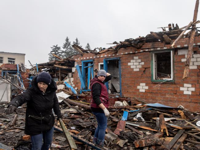 Residents work to clear debris from destroyed houses in Boromlya, Ukraine. The town was recently recaptured by Ukrainian forces. Picture: Chris McGrath/Getty Images