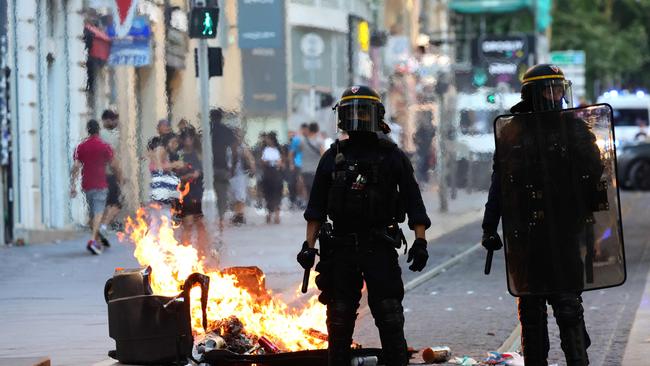 French riot police officers stand guard next to a burnt out trash bin during a demonstration against police in Marseille, southern France. Picture: AFP