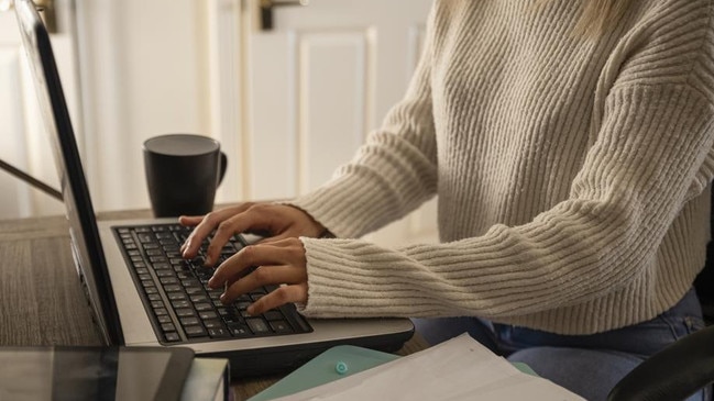 An unrecognisable young woman using her laptop and completing some work at home in Northumberland, North East England.