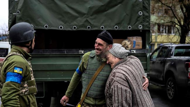 An elderly woman embraces an Ukranian soldier in Bucha, northwest of Kyiv. Picture: AFP