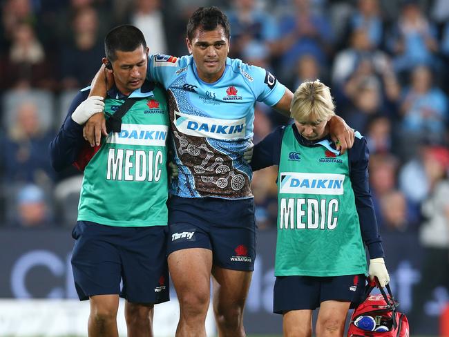 Karmichael Hunt is helped from the field after injuring his knee. Picture: Getty Images