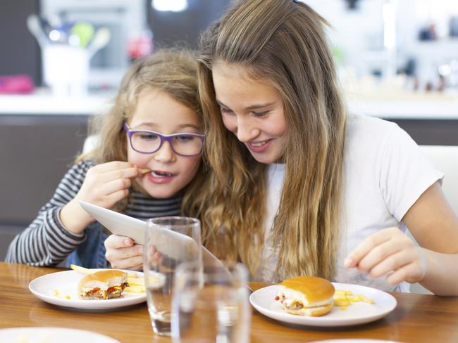 Screen time addicts ... kids are taking their gadgets to the dinner table at mealtime.