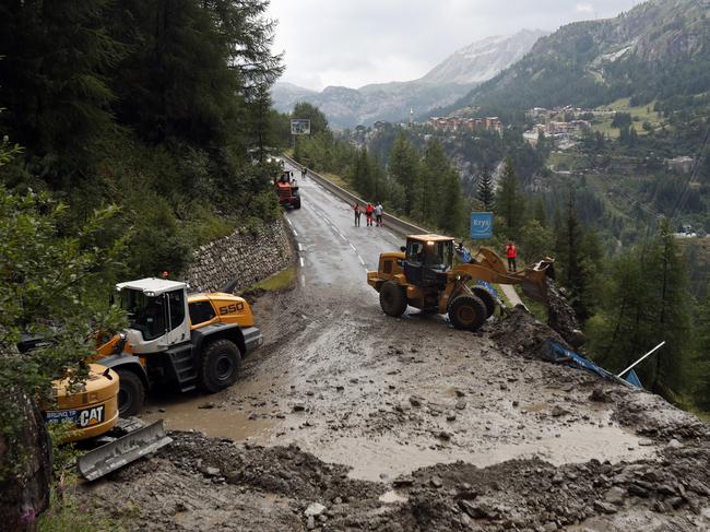 Worker use diggers to clean the road of the nineteenth stage of the Tour de France cycling race over 126,5 kilometers (78,60 miles) with start in Saint Jean De Maurienne and finish in Tignes, France, Friday, July 26, 2019. Organizers stopped the world's premier cycling event Friday for the riders' safety when a sudden, violent storm made the route through the Alps too dangerous. (AP Photo/Thibault Camus)